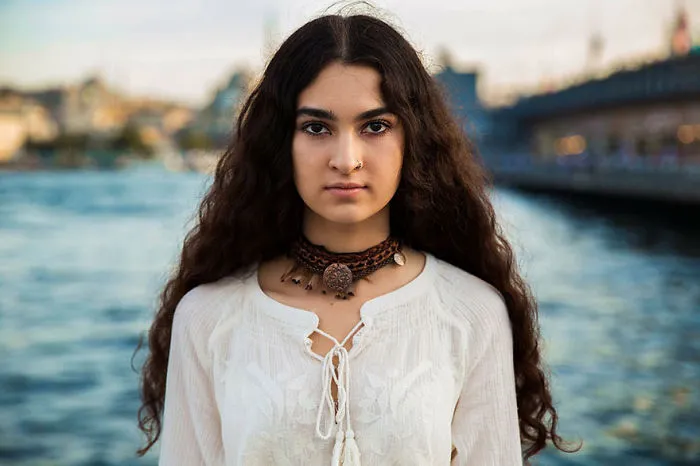 Woman photographed by Romanian photographer, showcasing cultural beauty by the water.