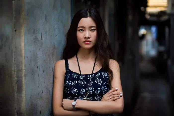 Portrait of a woman in a patterned dress, showcasing diverse beauty, photographed by a Romanian photographer.