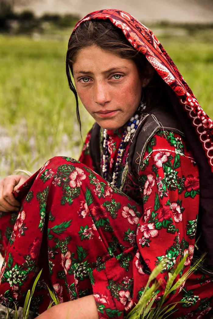 Romanian photographer captures woman's beauty in vibrant red floral dress, showcasing diversity in nature.