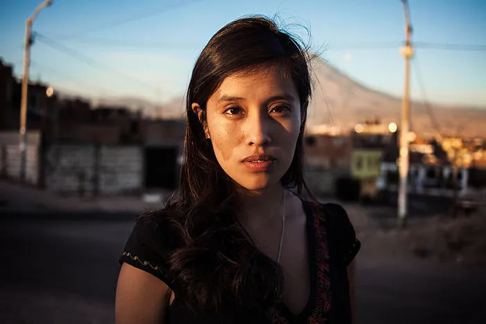Portrait by Romanian photographer showcasing beauty of women worldwide, with a mountainous backdrop.