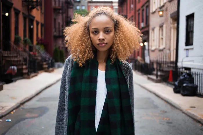Romanian photographer captures a woman standing in a vibrant street, showcasing global beauty.