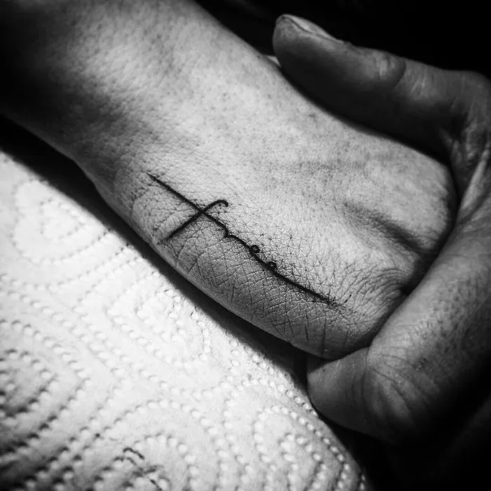 Minimalist tattoo of the word "free" on a hand, showcasing subtle ink art inspiration.