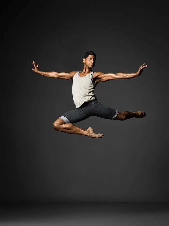 Ballet dancer performing a grand jeté mid-air, showcasing grace and athleticism.