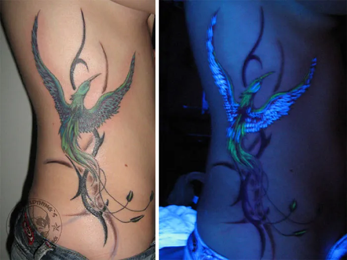 Glow in the dark tattoo of a bird on a side, visible under black light.