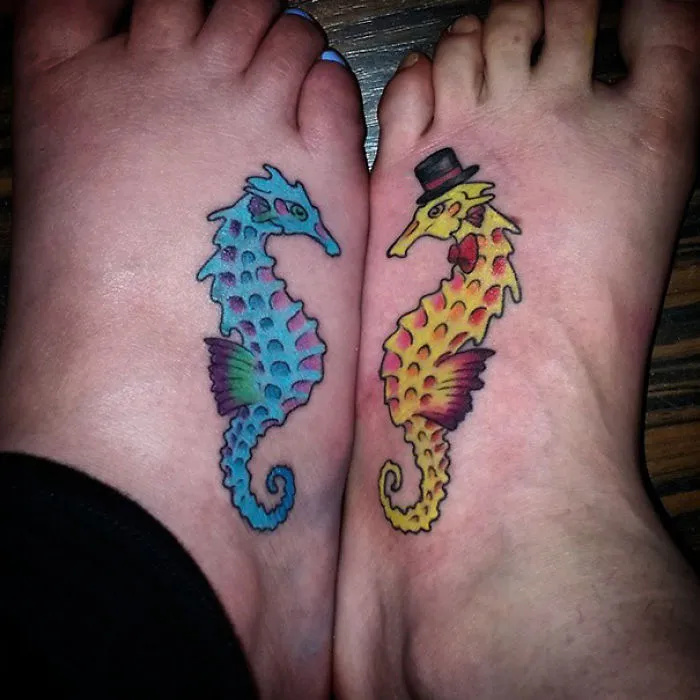 Seahorse sister tattoos on feet, colorful and unique design.