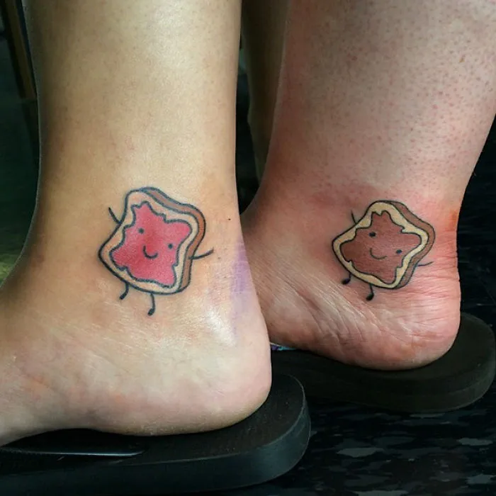 Cute matching sister tattoos of toast and jelly on ankles, symbolizing a special bond.