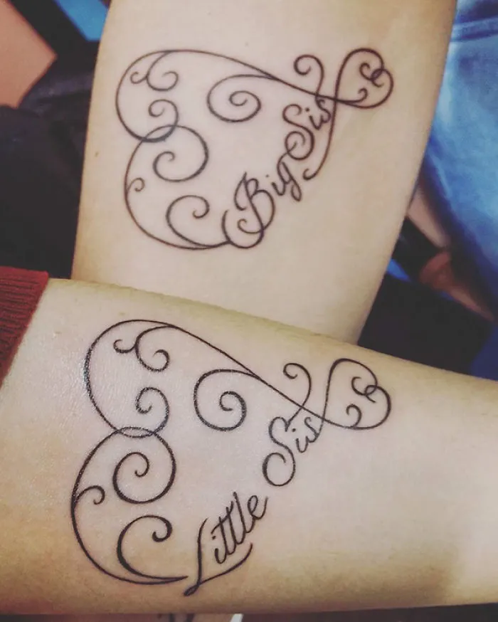 Two arms with matching sister tattoos reading "Big Sis" and "Little Sis" in elegant script.