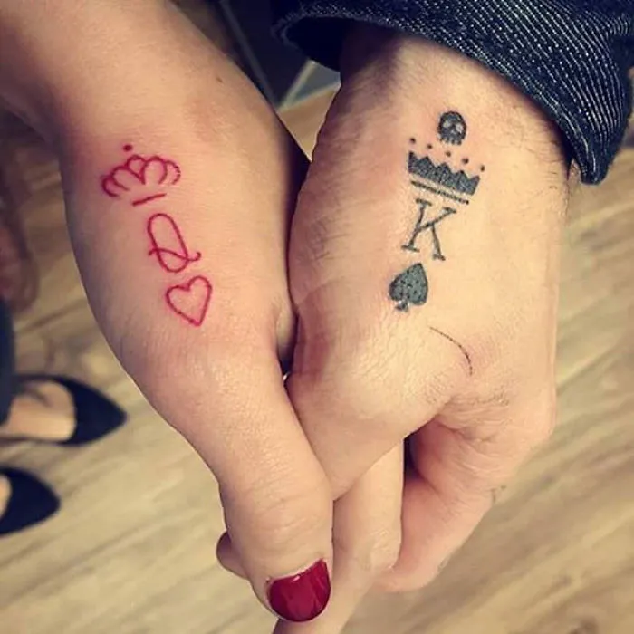Minimalist tattoos of king and queen symbols on hands.