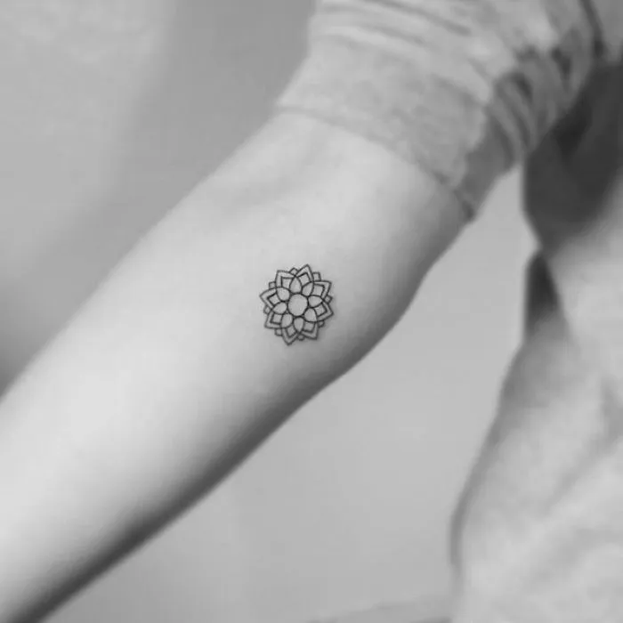 Minimalist tattoo of a geometric flower on an arm, showcasing simple and elegant ink art.