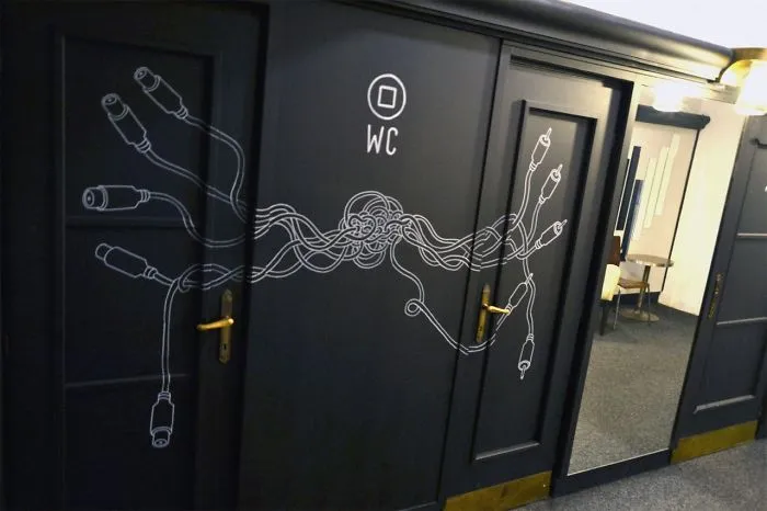 Funny bathroom sign featuring tangled cables on a WC door.