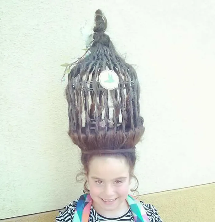 Child with birdcage-shaped hairdo for Crazy Hair Day, featuring intricate styling and colorful accessories.