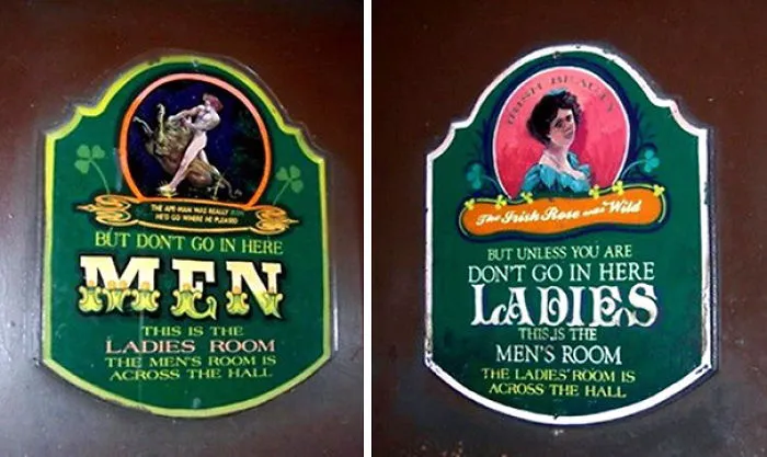 Funny bathroom signs with humorous gender mix-ups in a pub setting.