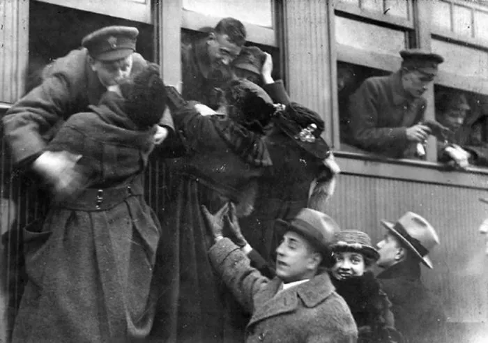 Couples embrace and kiss through train windows, showcasing historic love during wartime.