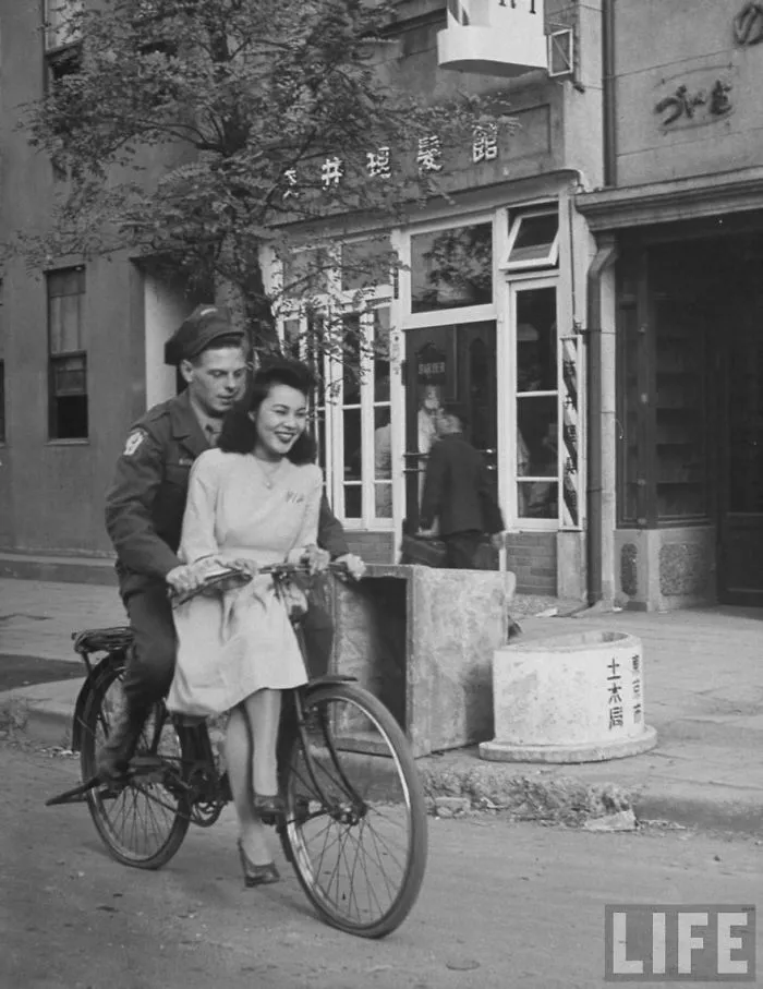 Soldier and woman sharing a bike ride, capturing a moment of love during wartime in a historic setting.