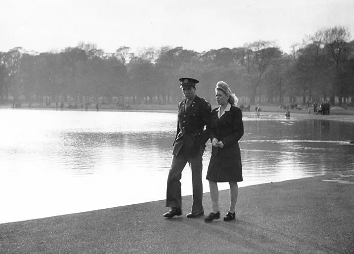 A couple walking by a lake, showcasing love during wartime.