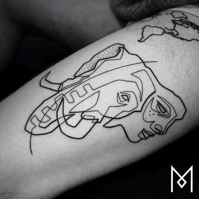 Minimalist single line tattoo of abstract faces on skin, created by Iranian-German artist.