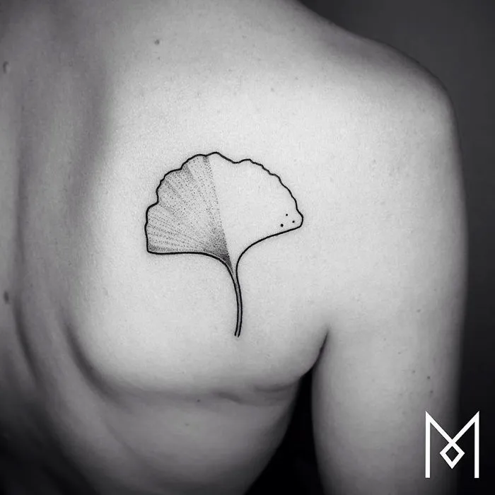 Minimalist single line tattoo of a ginkgo leaf on a person's back by Iranian-German artist.
