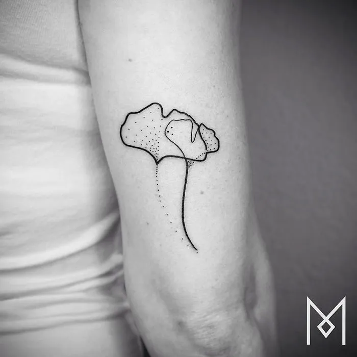 Minimalist single line tattoo on an arm, depicting abstract floral design by Iranian-German artist.