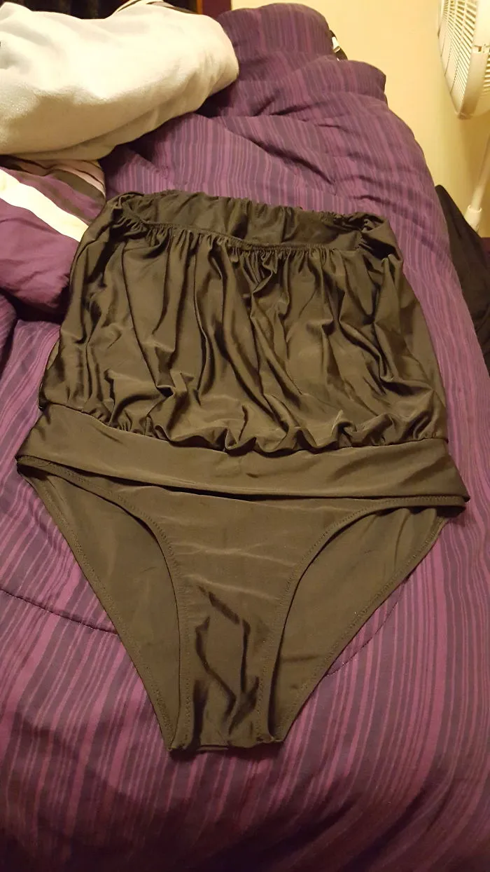 Large black swimsuit on a purple bed signifies deep regret over an online purchase.