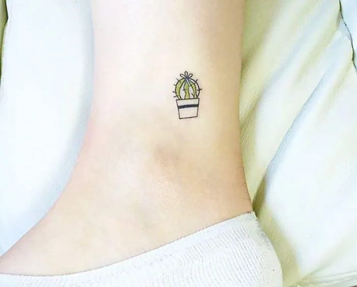 Small foot tattoo of a green cactus in a pot, showcasing minimalist design ideas.