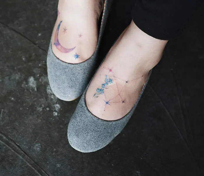 Minimalist small foot tattoos with starry designs and lavender motifs on both feet.