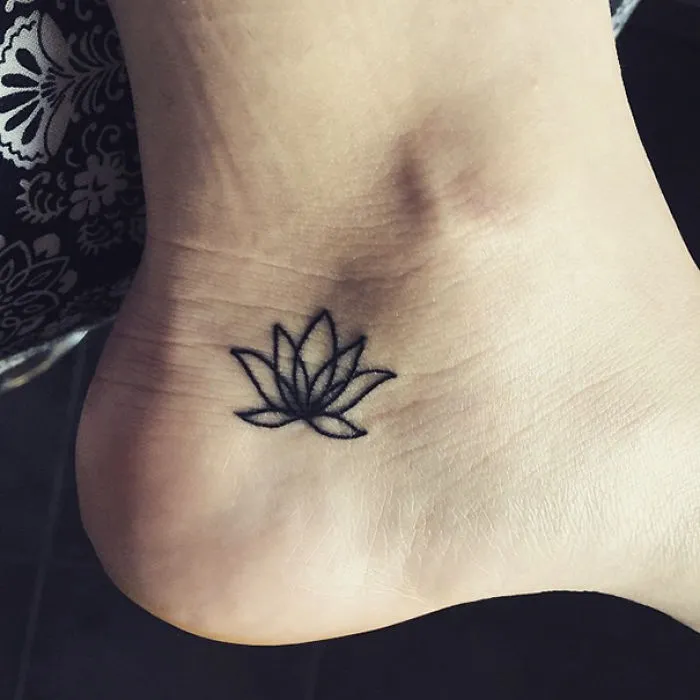 Small foot tattoo idea with a simple lotus design.