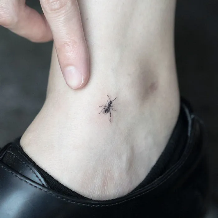 Small foot tattoo idea featuring a tiny ant, emphasizing minimalist design.