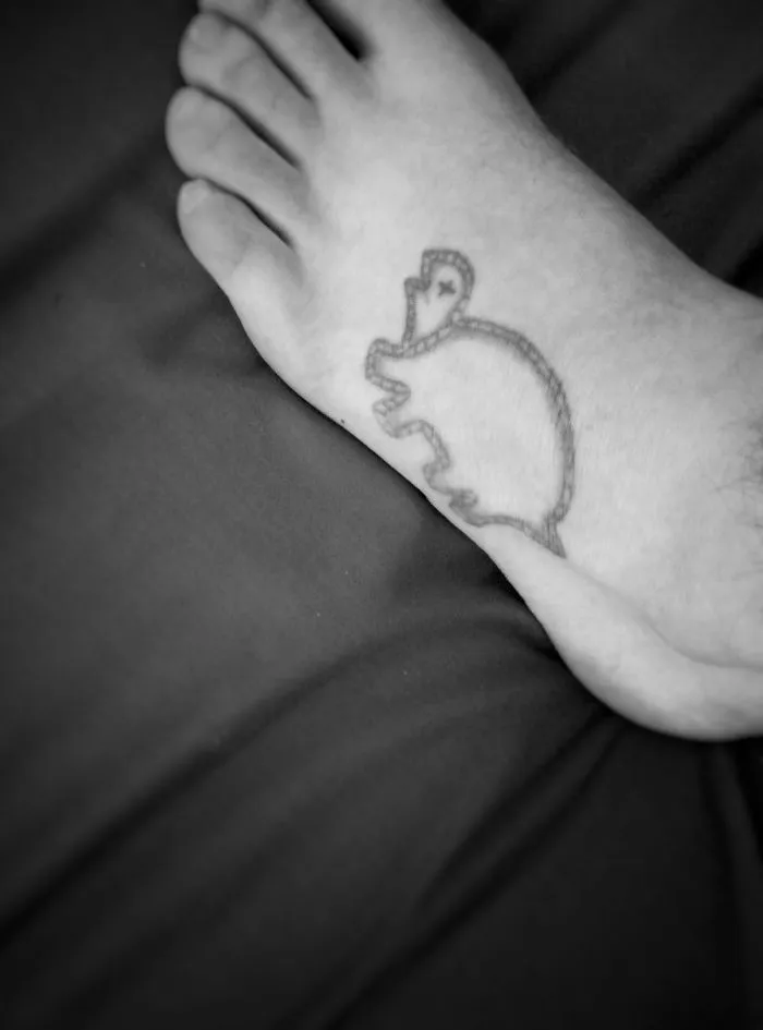 Small foot tattoo with a simplistic outline of an elephant, showcasing minimalistic design on light skin.