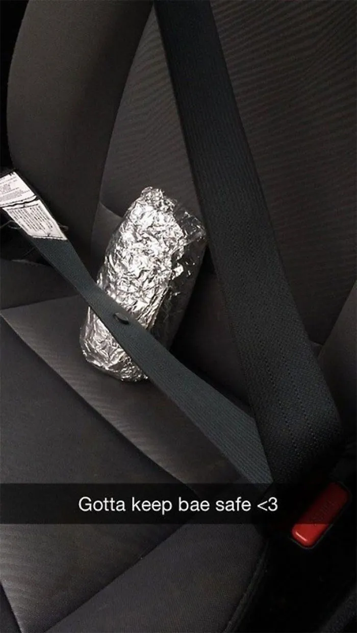 Funny Snapchat of a foil-wrapped burrito seat-belted in a car.