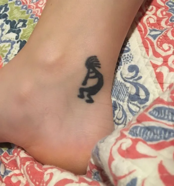 Minimalist small foot tattoo on ankle displaying creative tribal design.