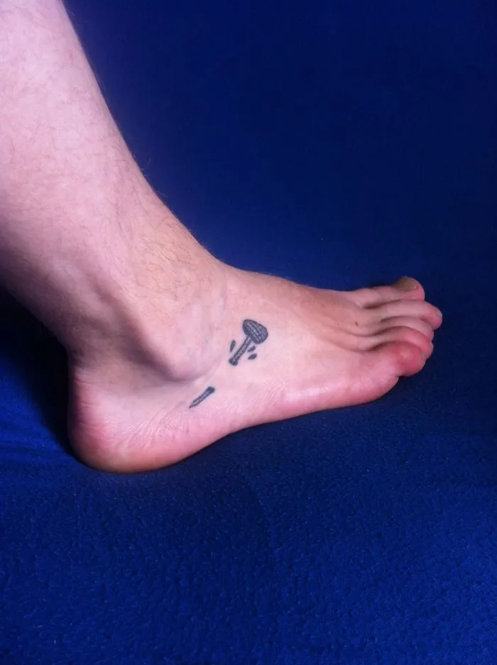 Small foot tattoo with a minimalist design of a showerhead on the side of a person's foot.