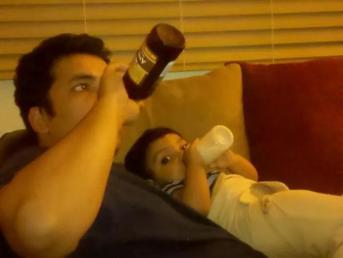 Man and child drinking bottles on couch illustrating kids can't be left alone with their dads