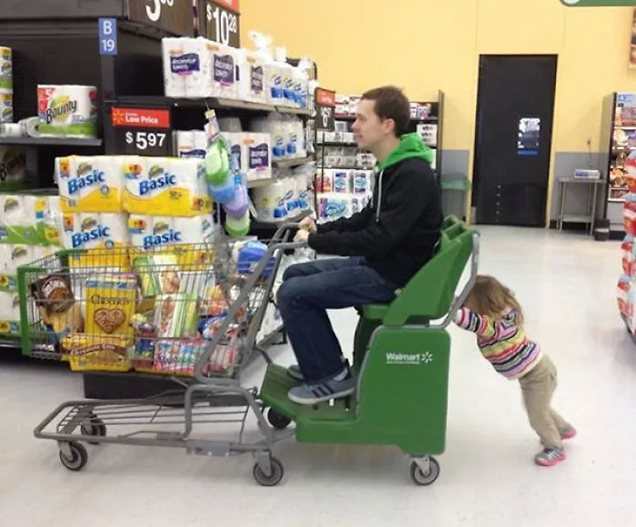 Dad riding motorized shopping cart with child pushing behind reasons kids can't be left alone with dads