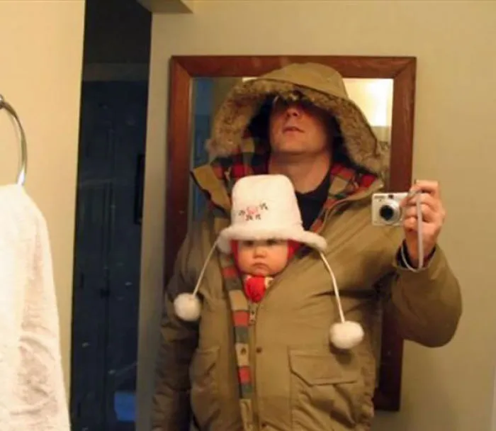 Father carrying baby inside jacket selfie showing kids cant be left alone with dads