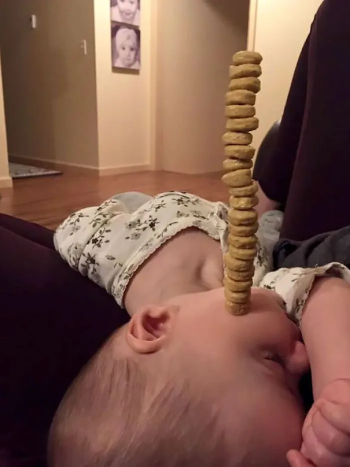 Baby asleep with cereal pieces stacked on face showing kids cant be left alone with dads
