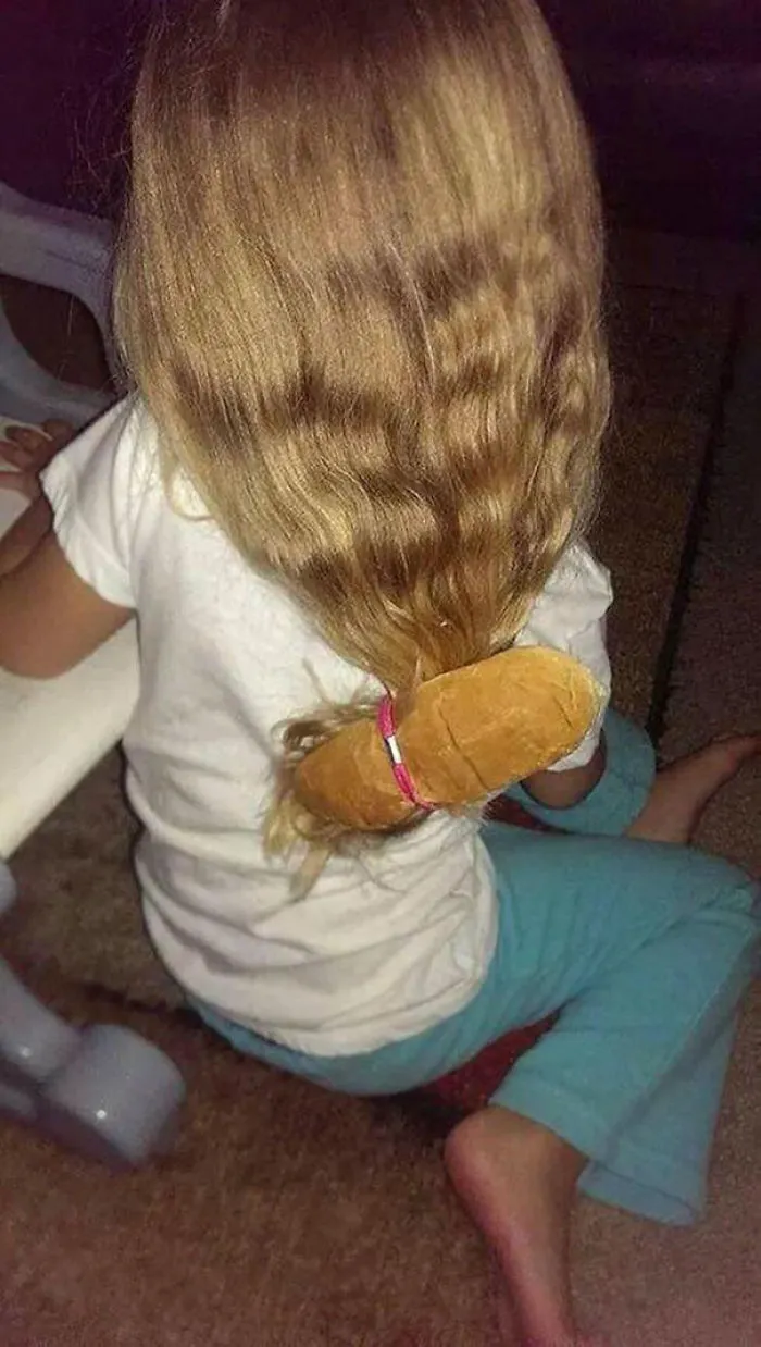 Child with hair tied using a bread roll as hair tie