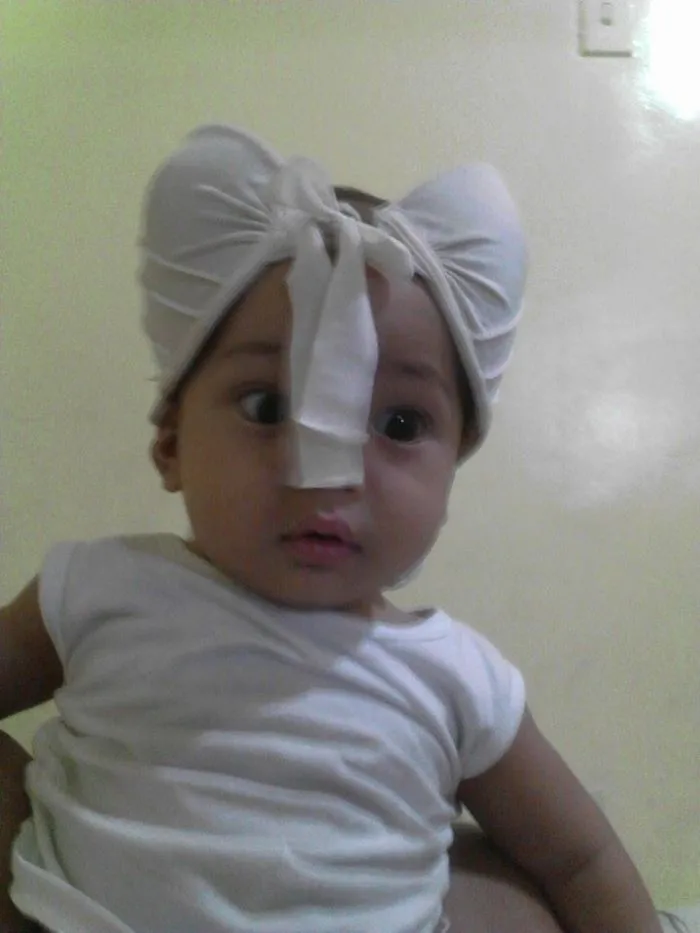 Baby with sock tied as headwear highlighting kids can't be left alone with dads