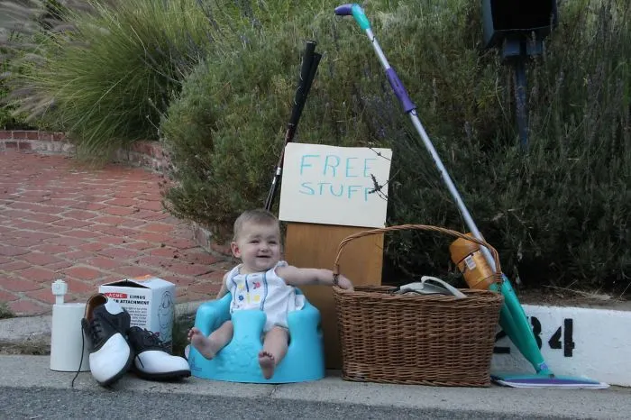 Baby sitting among free stuff sign and household items for kids can't be left alone with dads