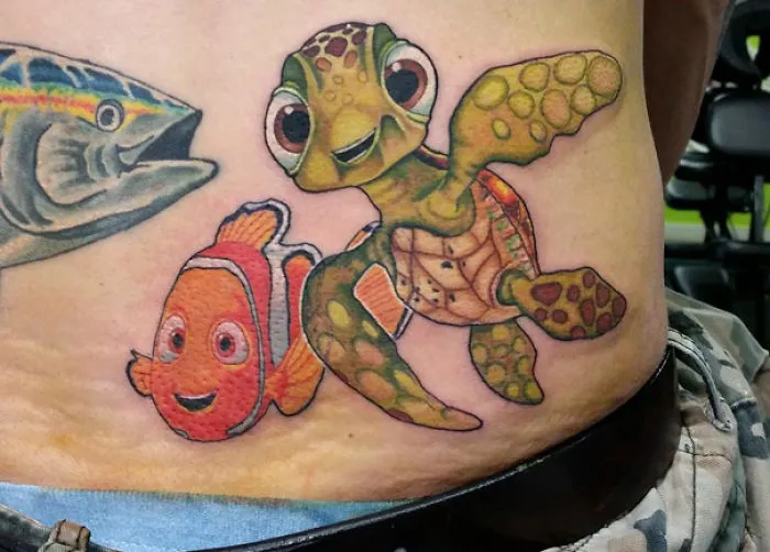 Pixar-inspired tattoo featuring a detailed depiction of a turtle and clownfish on a person's side.