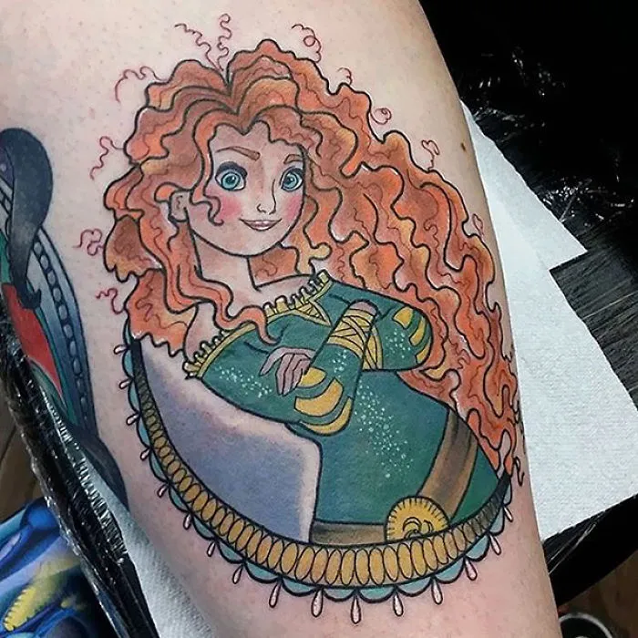 Pixar-inspired tattoo of a character with curly red hair and a green dress on an arm.