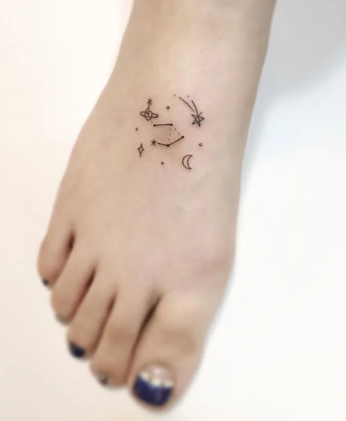Minimalist tattoo on a foot showing constellations and celestial symbols by a Korean artist.