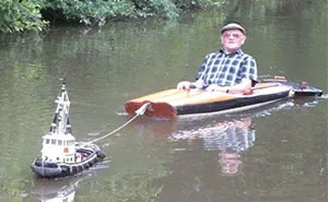 Man Spotted Using Tiny Tug Boat To Effortlessly Cruise Down The River