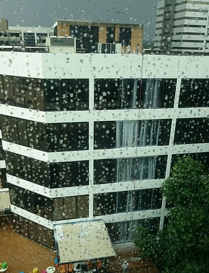 Building with window cleaning failure, water streaks visible on glass, highlighting a job not done properly.