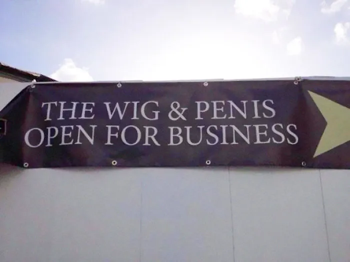 Banner with a humorous typo saying "The Wig & Penis Open for Business" illustrating a funny job fail.