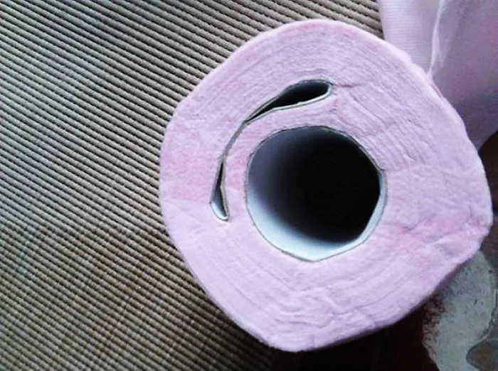 Pink toilet paper roll with a misaligned center, showcasing a funny fail.
