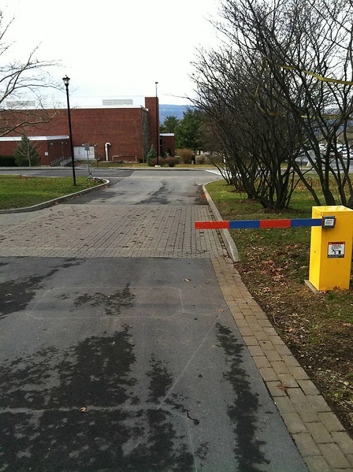 Parking lot with misplaced barrier blocking sidewalk; a classic job fail.