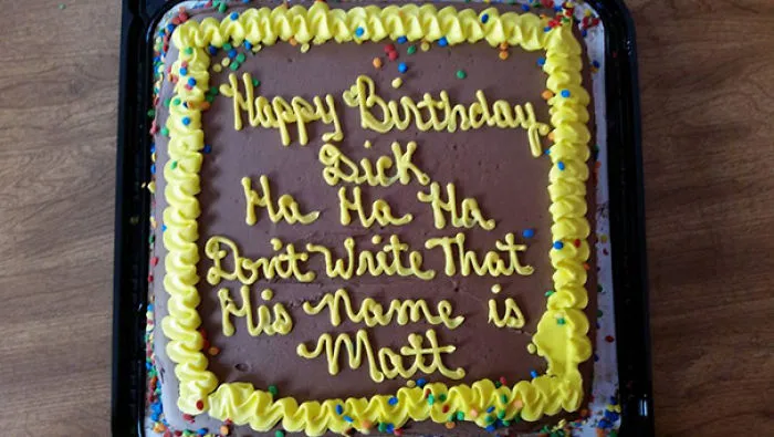 Birthday cake fail with humorous message instead of correct greeting.