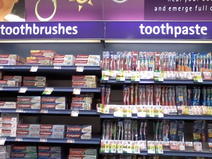 Toothpaste displayed under toothbrush sign in a store aisle, illustrating a job fail.