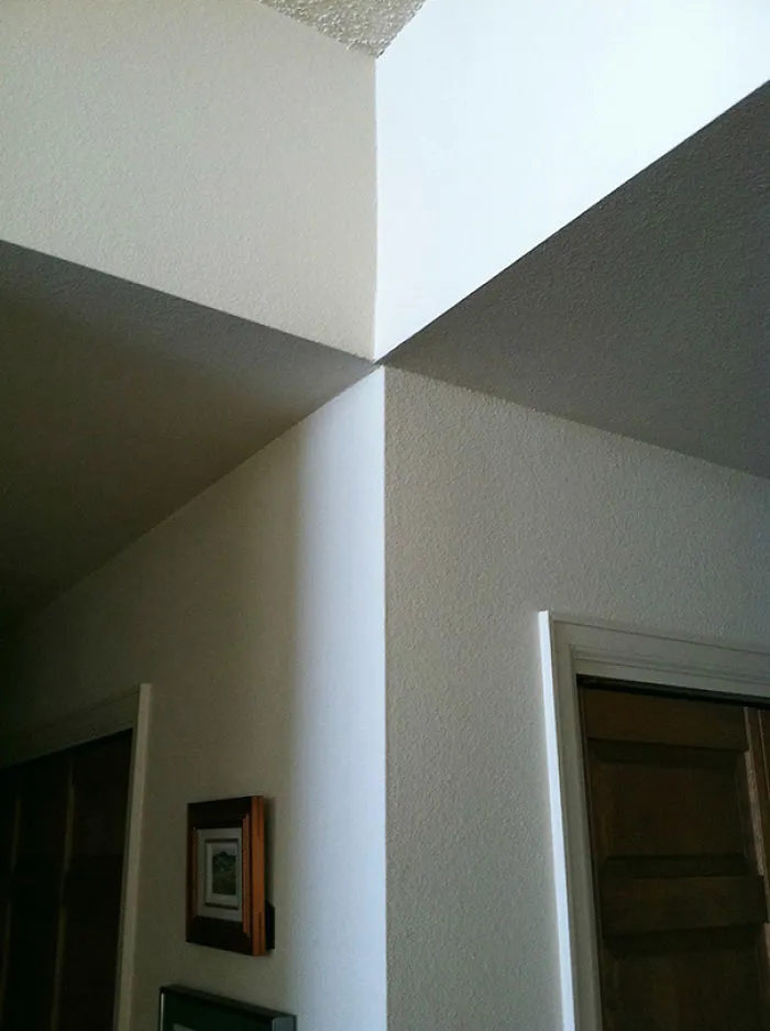 Uneven walls meeting awkwardly at a corner, illustrating a job fail in construction.
