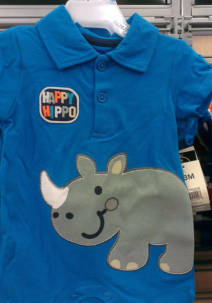 Blue baby outfit with "Happy Hippo" text and a rhinoceros graphic, highlighting a design fail.